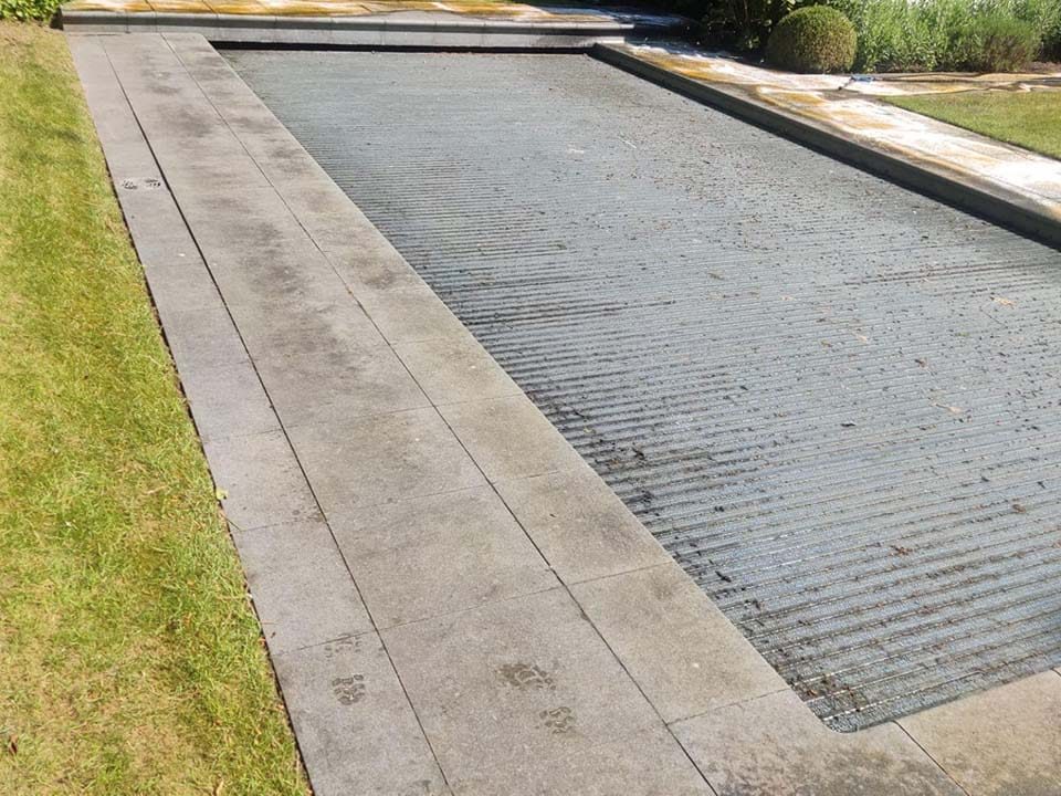 Vervuilde tuintegels met groene aanslag voor de reiniging
